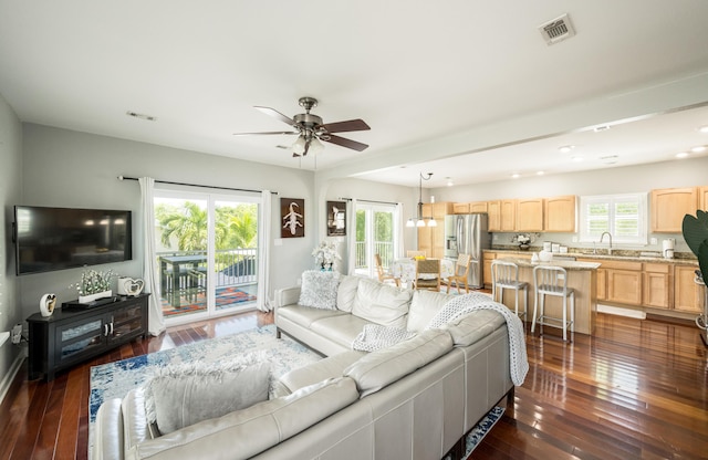 living room with plenty of natural light, dark hardwood / wood-style floors, sink, and ceiling fan