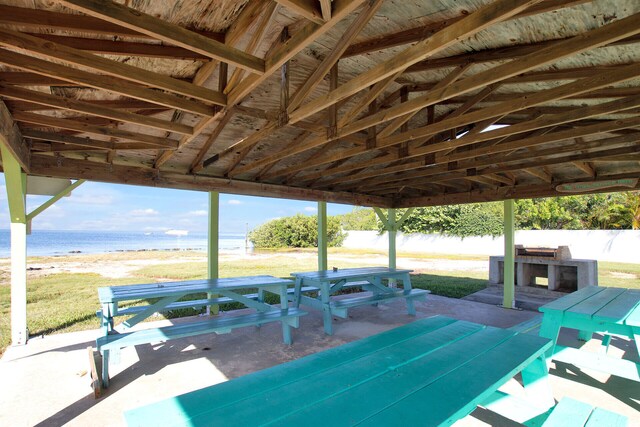 view of patio featuring a beach view and a water view