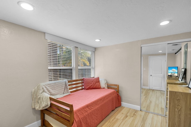 bedroom featuring a textured ceiling and light wood-type flooring