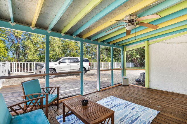 sunroom featuring beamed ceiling and ceiling fan