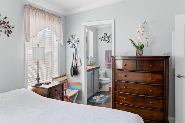 bedroom featuring connected bathroom and ornamental molding