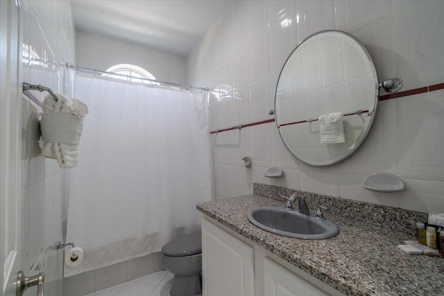 full bathroom with toilet, tile walls, vanity, shower / bath combo, and tile patterned flooring