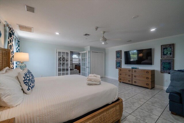 tiled bedroom with ceiling fan, ornamental molding, and a closet