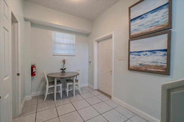 dining space with a textured ceiling and light tile patterned floors