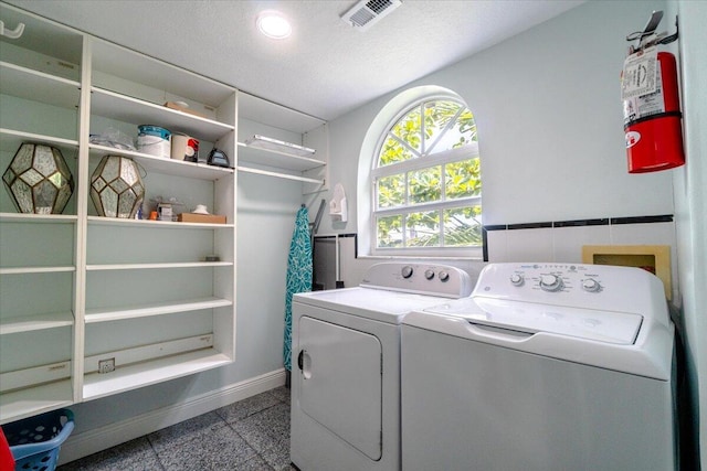 washroom featuring independent washer and dryer and a textured ceiling