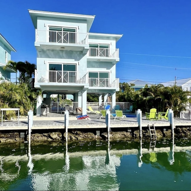 rear view of house featuring a water view and a balcony