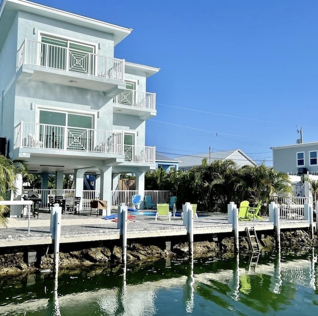 rear view of house featuring a balcony and a water view