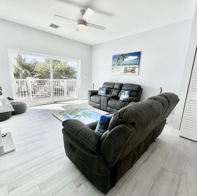 living room with ceiling fan and light hardwood / wood-style flooring