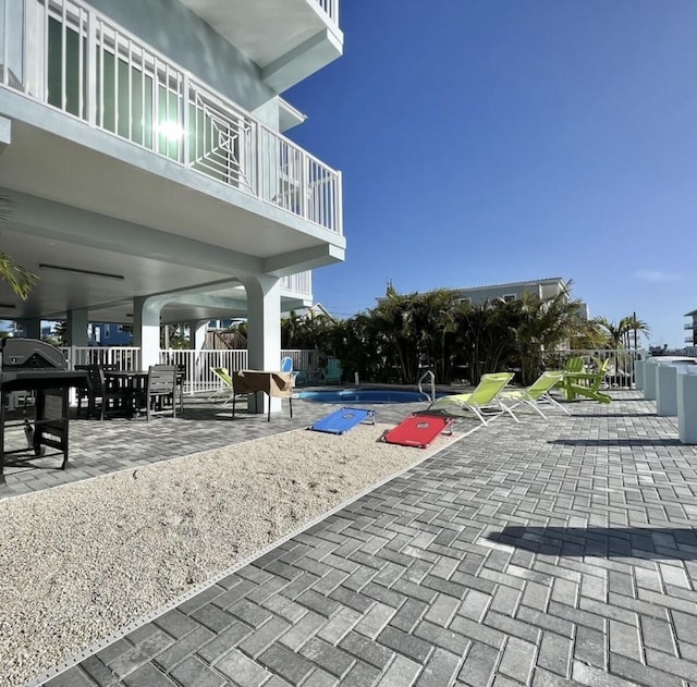 view of property's community featuring a pool and a patio