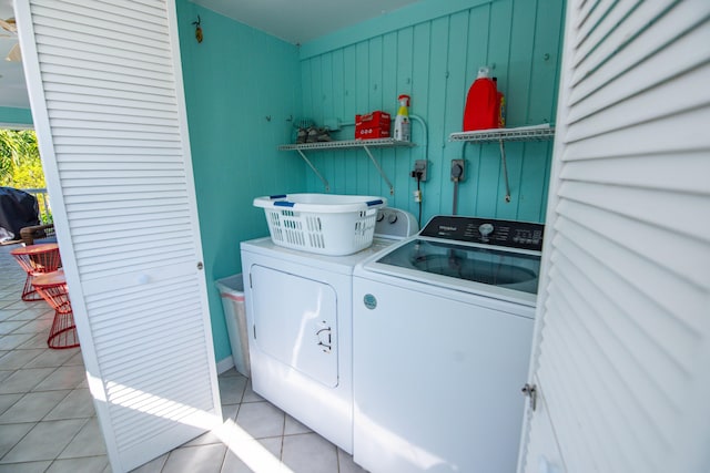 clothes washing area featuring independent washer and dryer and light tile patterned flooring