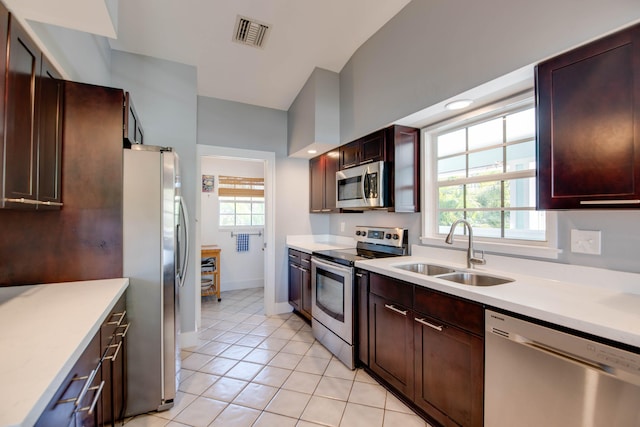 kitchen with stainless steel appliances, sink, and light tile patterned floors