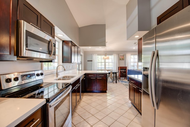 kitchen featuring light tile patterned flooring, sink, hanging light fixtures, kitchen peninsula, and stainless steel appliances