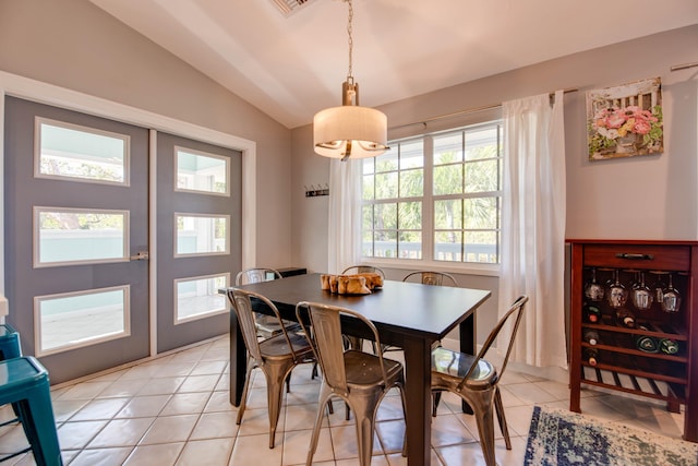 dining room featuring vaulted ceiling and light tile patterned floors