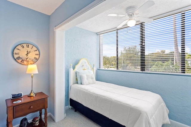 bedroom with ceiling fan and a textured ceiling