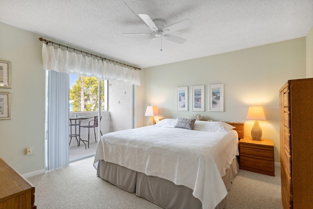 bedroom with ceiling fan, access to outside, light colored carpet, and a textured ceiling