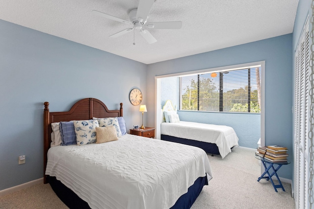 carpeted bedroom with ceiling fan and a textured ceiling