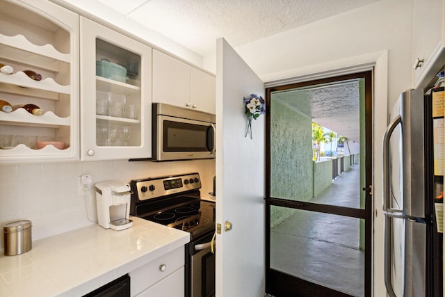 kitchen with white cabinetry, stainless steel appliances, and decorative backsplash