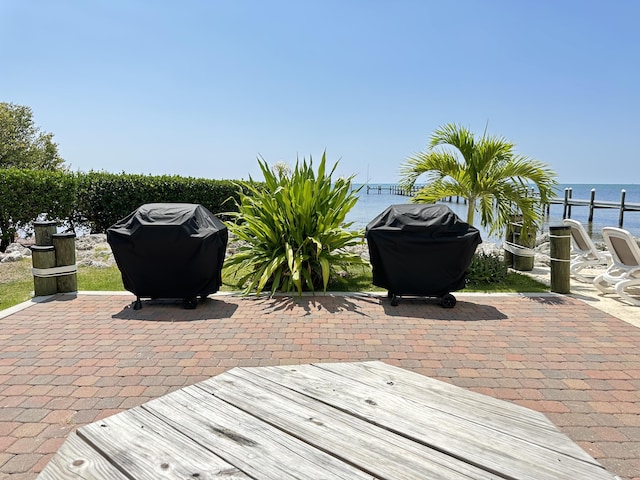 view of patio featuring a water view and area for grilling