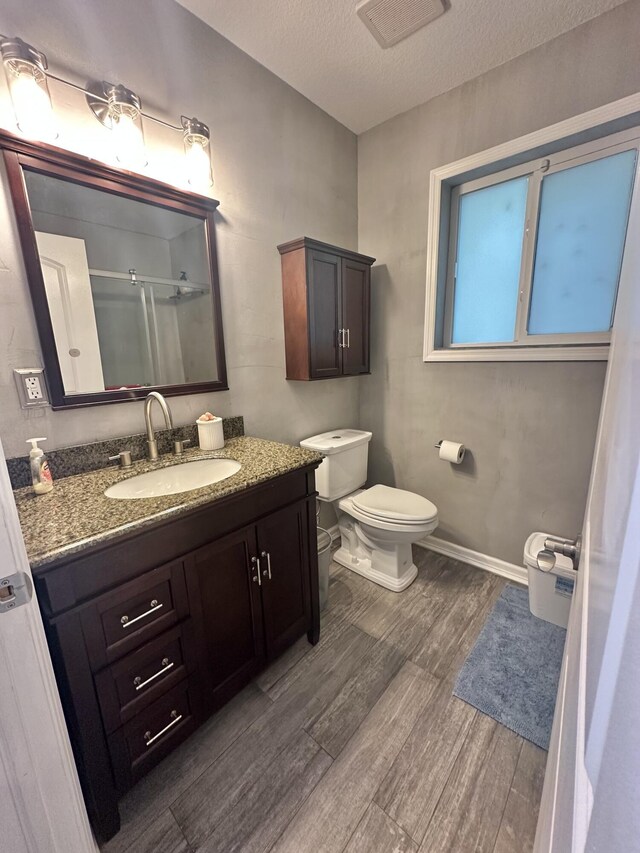 349 Mahogany Dr, Key Largo, FL 33037 - full bathroom with wood finished floors, vanity, a textured ceiling, and a shower with shower door