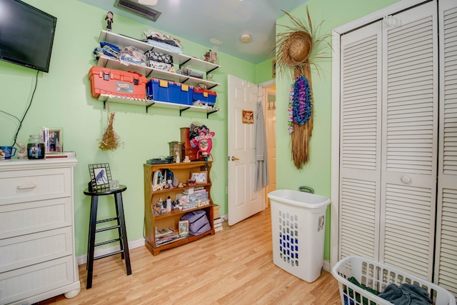 playroom with wood finished floors, visible vents, and baseboards