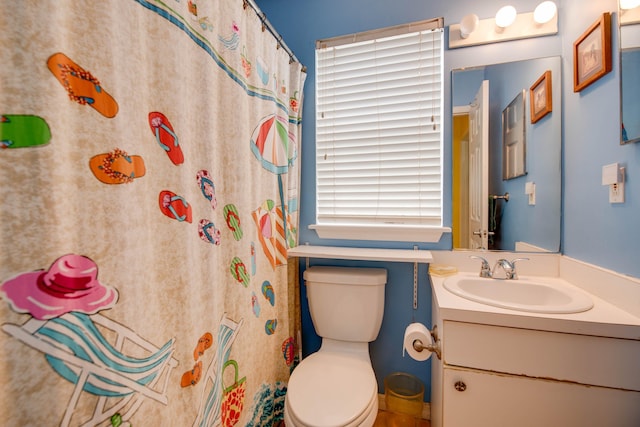 bathroom with curtained shower, vanity, and toilet