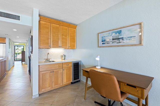 kitchen with light tile patterned flooring, tasteful backsplash, sink, wine cooler, and fridge