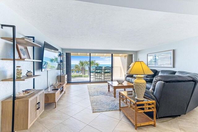 tiled living room featuring expansive windows and a textured ceiling