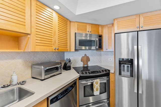 kitchen with stainless steel appliances, sink, light brown cabinets, and backsplash