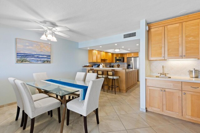 dining room featuring light tile patterned floors, a textured ceiling, and ceiling fan