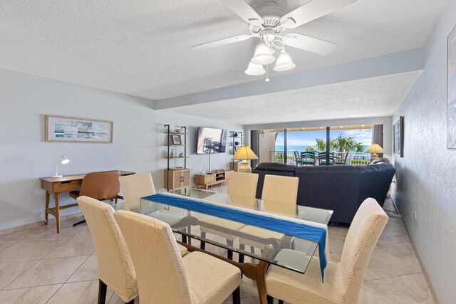 tiled dining room with ceiling fan and a textured ceiling