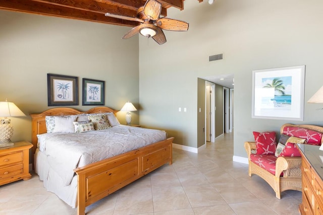 tiled bedroom with ceiling fan and a high ceiling