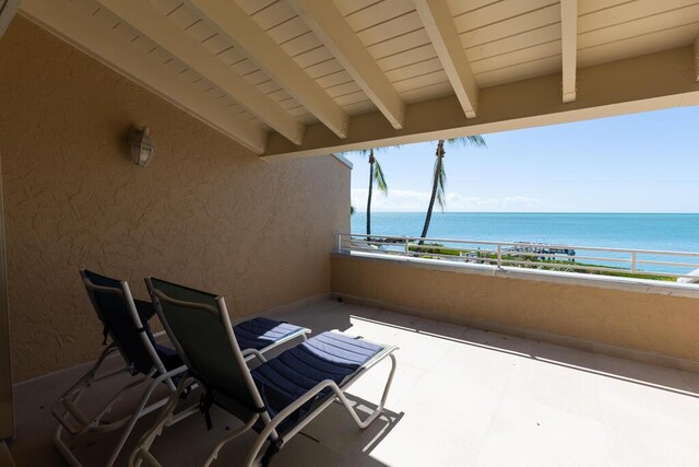 view of patio / terrace with a balcony and a water view