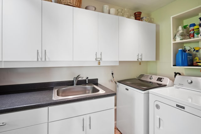 clothes washing area with cabinet space, washing machine and dryer, and a sink