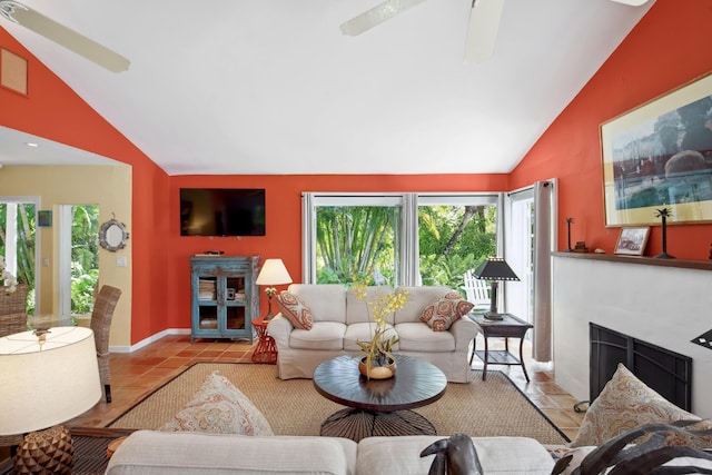 living area featuring lofted ceiling, ceiling fan, light tile patterned floors, and a fireplace with flush hearth