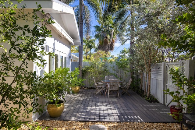 wooden terrace featuring outdoor dining space and a fenced backyard