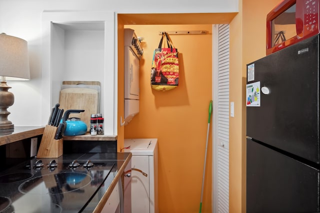 laundry area featuring a sink and stacked washer and clothes dryer