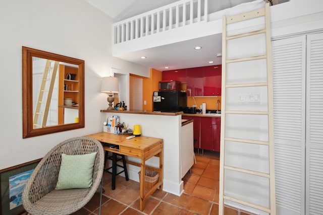 kitchen with a peninsula, dark tile patterned floors, freestanding refrigerator, and recessed lighting