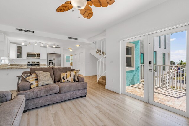 living room with sink, ceiling fan, track lighting, light wood-type flooring, and french doors