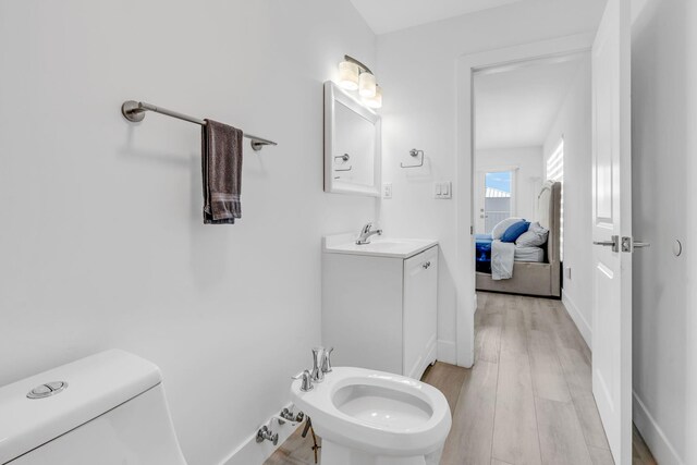 bathroom featuring a bidet, hardwood / wood-style floors, vanity, and toilet