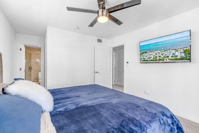 bedroom with connected bathroom, light hardwood / wood-style floors, and ceiling fan