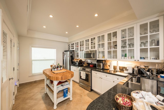 5960 Peninsular Ave Unit 108, Stock Island, FL 33040 - kitchen featuring appliances with stainless steel finishes, white cabinets, recessed lighting, glass insert cabinets, and a raised ceiling