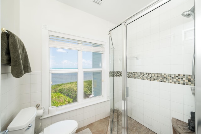 5960 Peninsular Ave Unit 108, Stock Island, FL 33040 - full bathroom featuring tile walls, toilet, a water view, a shower stall, and healthy amount of natural light