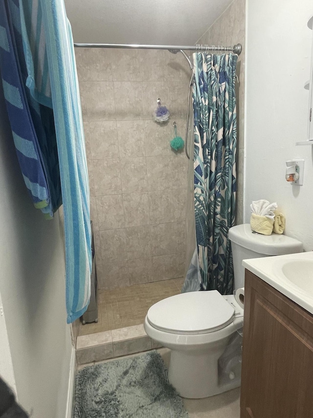 bathroom featuring vanity, curtained shower, and toilet