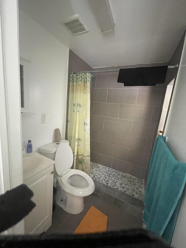 bathroom with walk in shower, vanity, and toilet