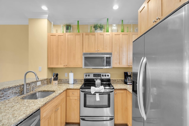 kitchen with light stone counters, sink, stainless steel appliances, and light brown cabinets