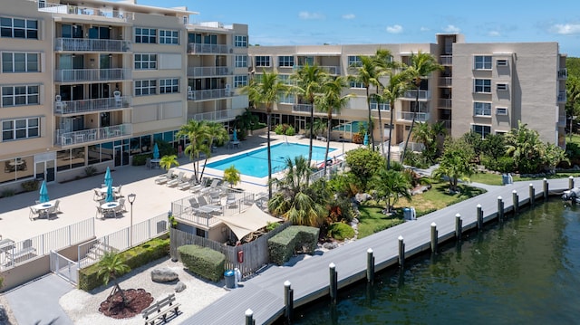 view of pool featuring a water view and a patio