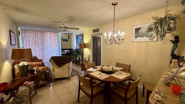 dining room with light tile patterned flooring, ceiling fan with notable chandelier, and a textured ceiling