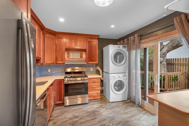 kitchen with stacked washer and clothes dryer, brown cabinets, tasteful backsplash, light countertops, and appliances with stainless steel finishes