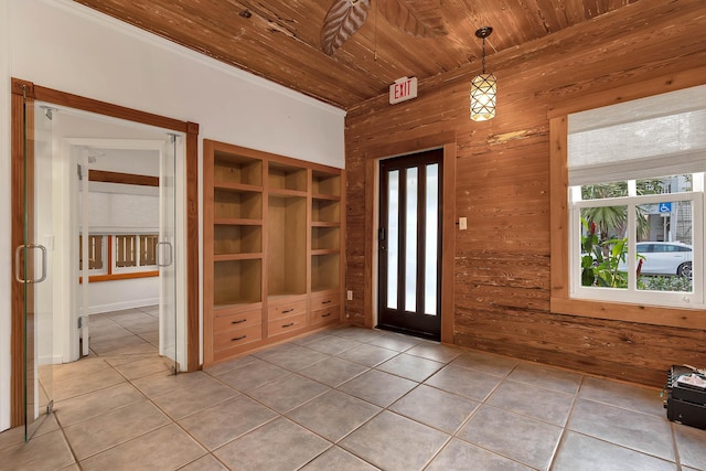 foyer featuring tile patterned flooring, wooden ceiling, and wood walls