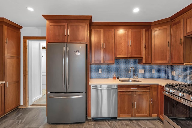 kitchen with stainless steel appliances, a sink, light countertops, and brown cabinets